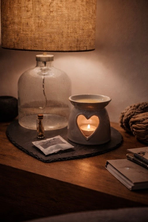 A cosy evening scene with a wax warmer gently filling a warm, dimly lit room with home fragrance